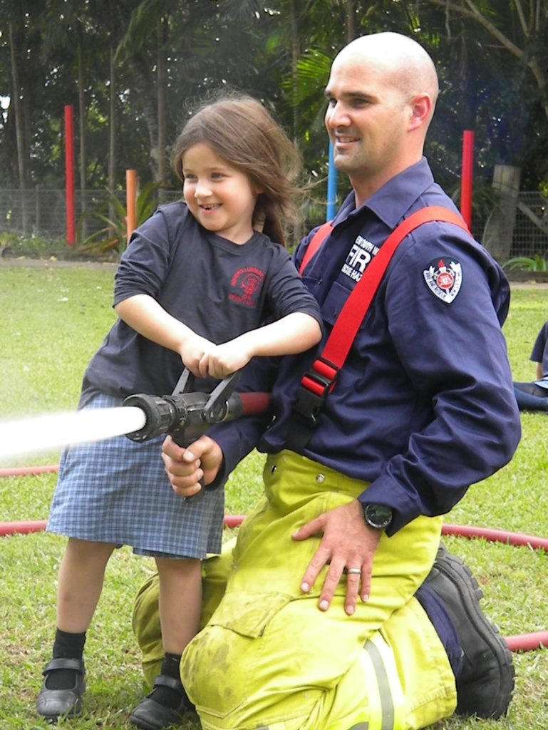 Kindergarten student Ruby Nichol and Fireman Hugh take aim at an orange safety cone. Kindergarten student Ruby Nichol and Fireman Hugh take aim at an orange safety cone.